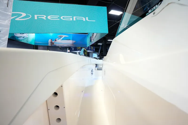 Slide: The Image of 2025 Regal 33 SAV boat showcased at an indoor exhibition with promotional banners. - 16