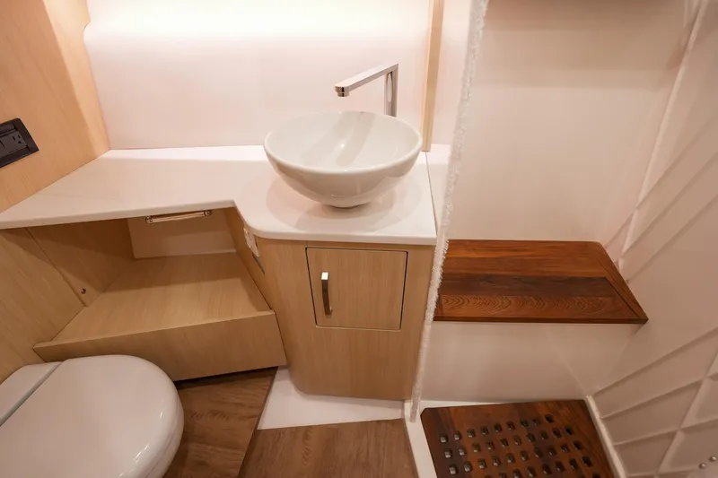 Slide: The Image of Modern bathroom interior of 2025 Regal 33 SAV boat, featuring sleek sink and wooden accents. - 21
