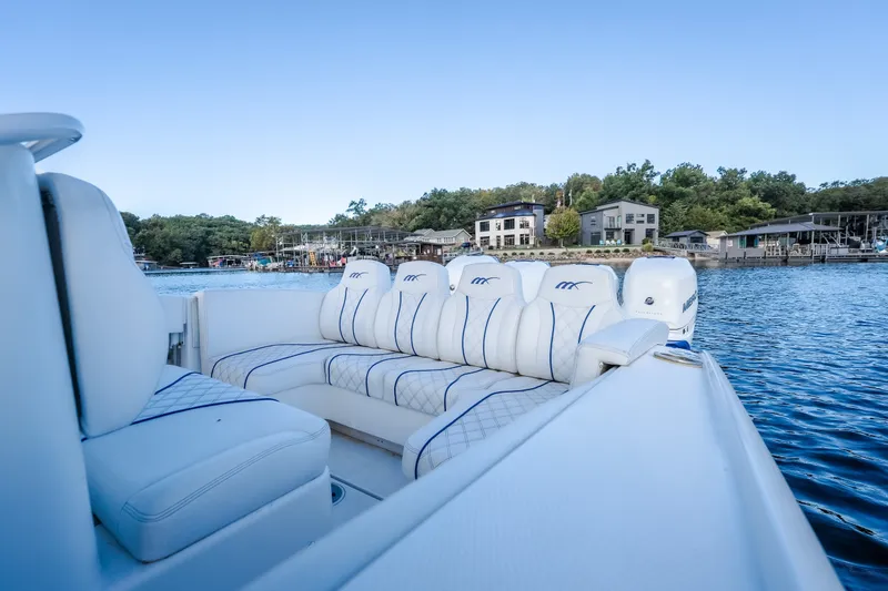 Slide: The Image of Luxurious seating on a 2017 Midnight Express 39S Cuddy boat by a serene waterfront. - 18