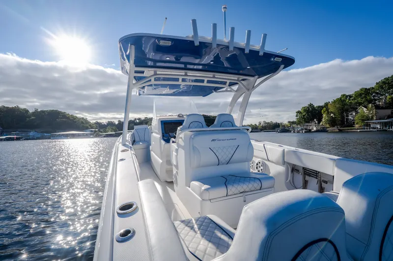 Slide: The Image of 2017 Midnight Express 39S Cuddy boat on a sunny lake, featuring luxurious seating. - 14