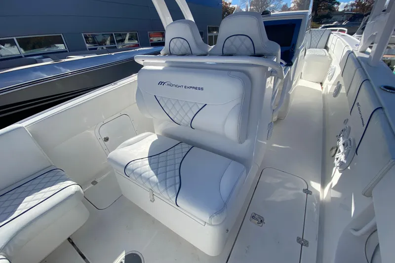 Slide: The Image of 2017 Midnight Express 39S Cuddy boat interior with white cushioned seating and sleek design. - 10