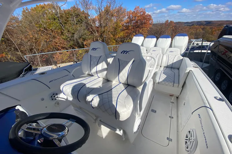 Slide: The Image of 2017 Midnight Express 39S Cuddy boat interior with white seating and steering wheel. - 14