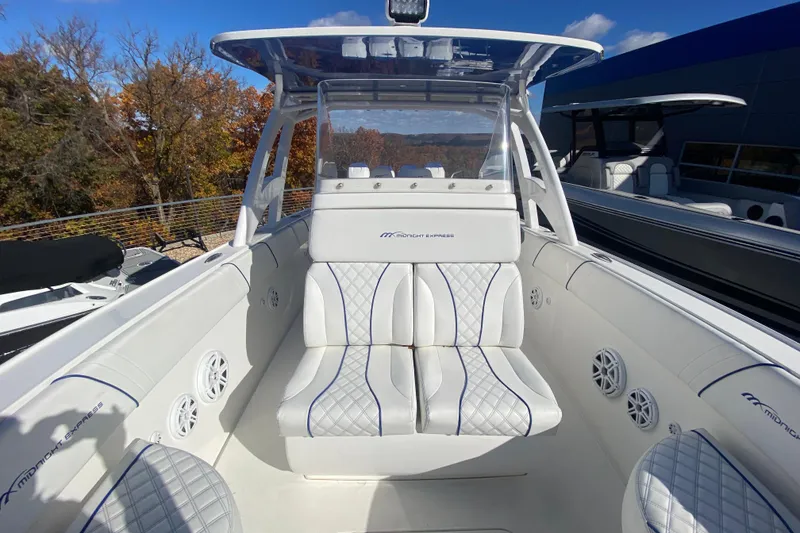 Slide: The Image of 2017 Midnight Express 39S Cuddy boat interior with white seating and blue accents. - 18