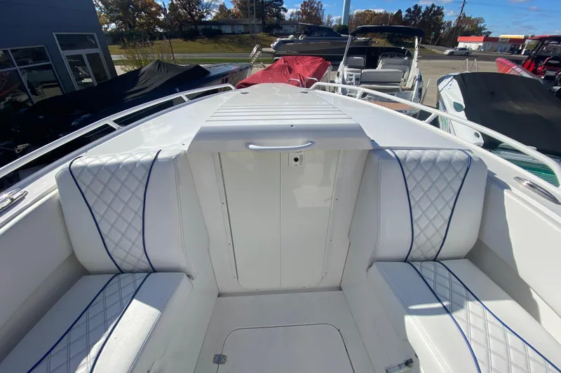 Slide: The Image of 2017 Midnight Express 39S Cuddy boat interior with white cushioned seating and blue accents. - 19