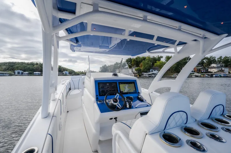 Slide: The Image of 2017 Midnight Express 39S Cuddy boat interior with modern navigation system on a serene lake. - 26