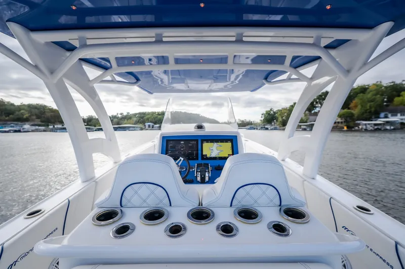 Slide: The Image of 2017 Midnight Express 39S Cuddy boat cockpit with advanced navigation system on a serene lake. - 53