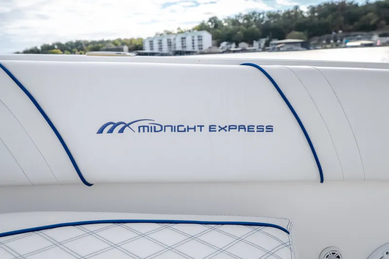 Slide: The Image of 2017 Midnight Express 39S Cuddy boat interior with logo, featuring white and blue upholstery. - 50