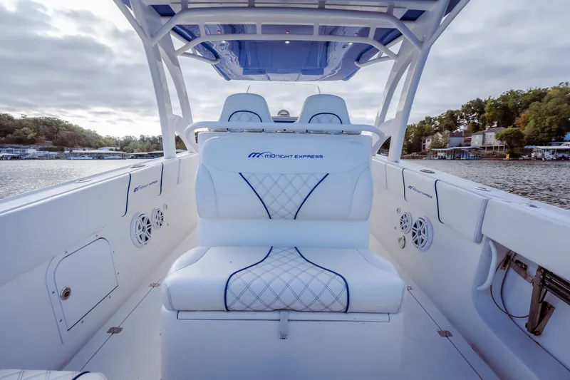 Slide: The Image of 2017 Midnight Express 39S Cuddy boat interior with white seating and lake view. - 16