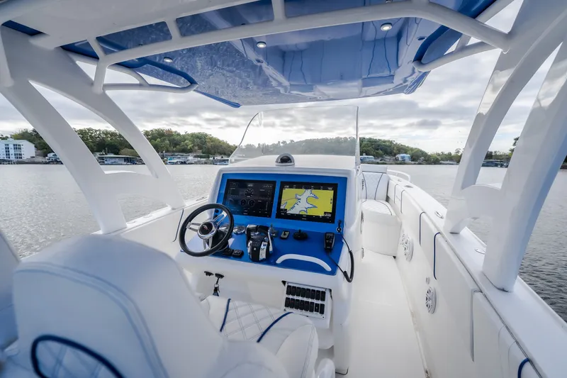 Slide: The Image of 2017 Midnight Express 39S Cuddy boat interior with modern navigation system on a calm lake. - 24