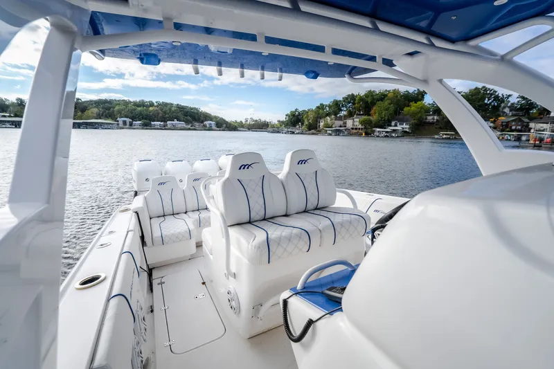 Slide: The Image of 2017 Midnight Express 39S Cuddy boat interior with luxurious seating on a serene lake. - 37