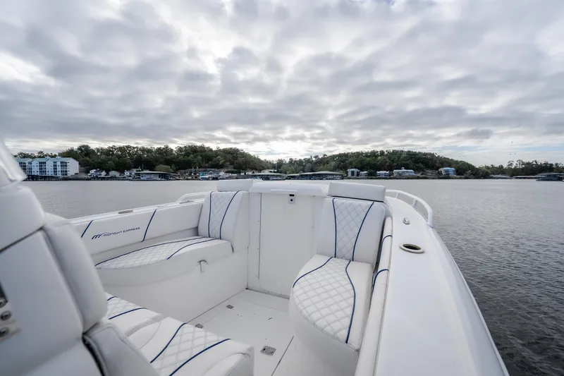Slide: The Image of 2017 Midnight Express 39S Cuddy boat interior with plush seating on a serene lake. - 38