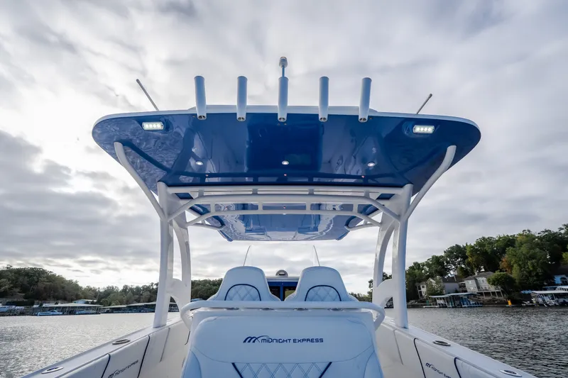 Slide: The Image of 2017 Midnight Express 39S Cuddy boat with blue canopy on a cloudy day. - 22