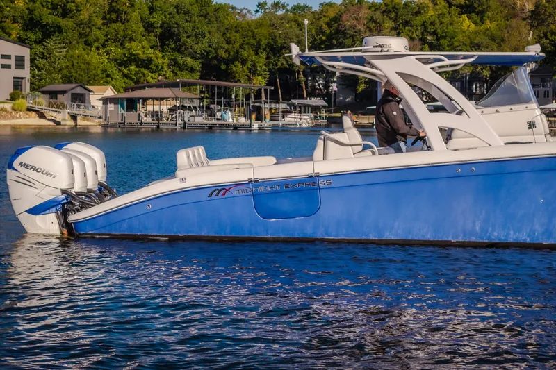 Slide: The Image of 2017 Midnight Express 39S Cuddy boat with Mercury engines on a serene lake. - 8