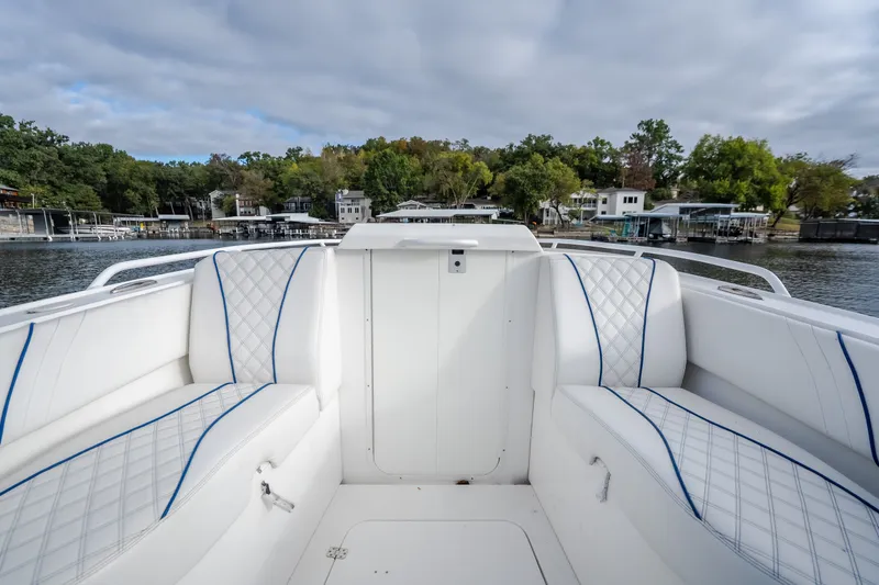 Slide: The Image of 2017 Midnight Express 39S Cuddy boat interior with white cushioned seating, dockside view. - 39