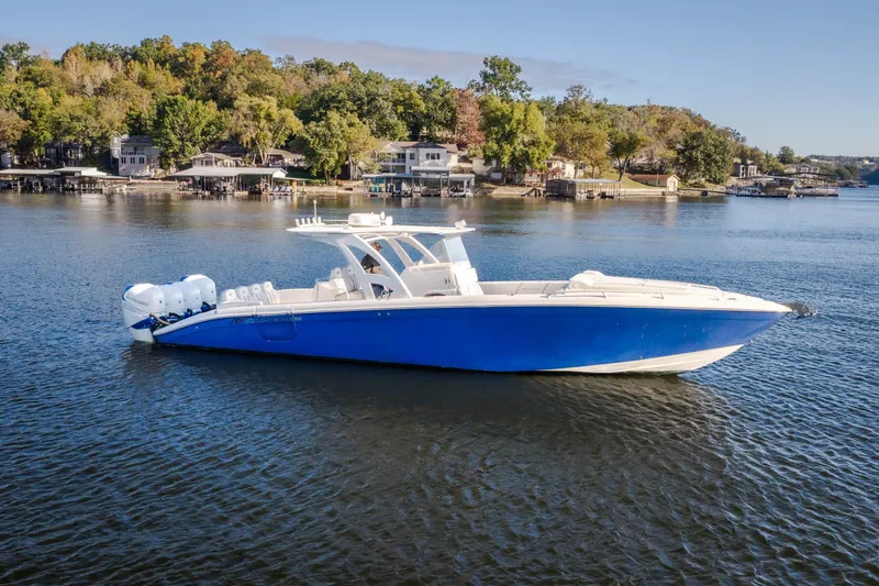Slide: The Image of 2017 Midnight Express 39S Cuddy boat on a serene lake with lush shoreline. - 5