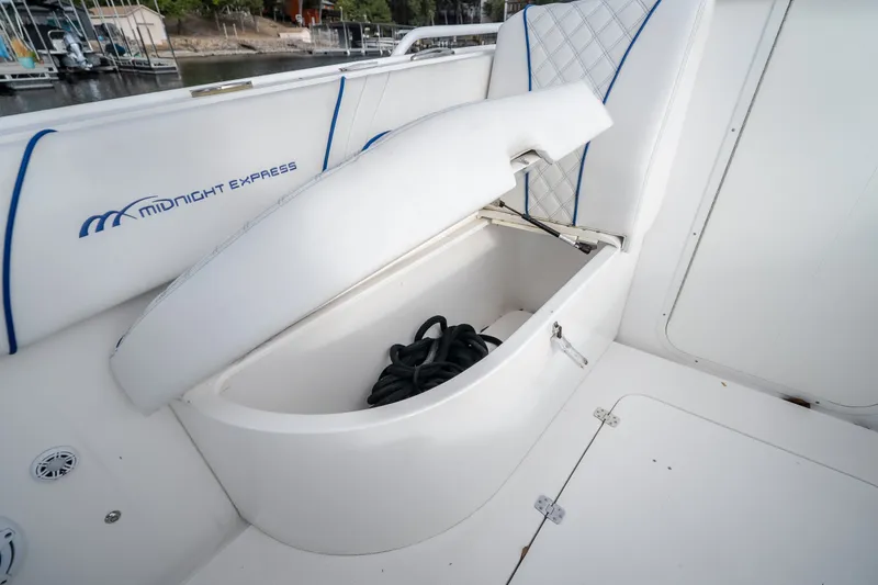 Slide: The Image of 2017 Midnight Express 39S Cuddy boat storage compartment with open lid and coiled rope. - 51