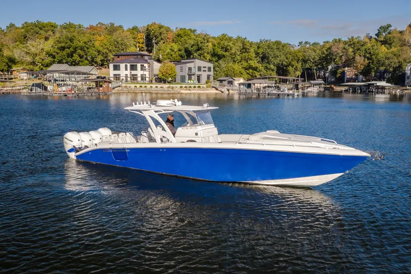 Slide: The Image of 2017 Midnight Express 39S Cuddy boat cruising on a serene lake with scenic background. - 3
