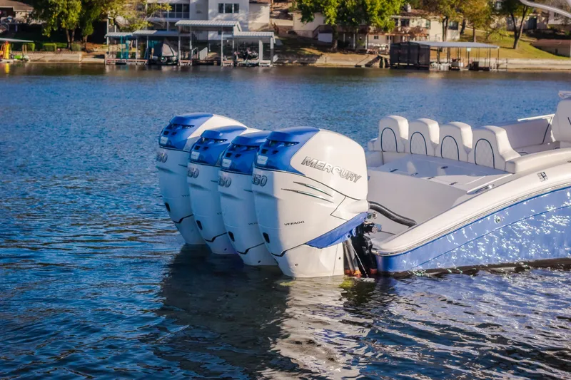 Slide: The Image of 2017 Midnight Express 39S Cuddy boat with four Mercury outboard engines on a serene lake. - 10