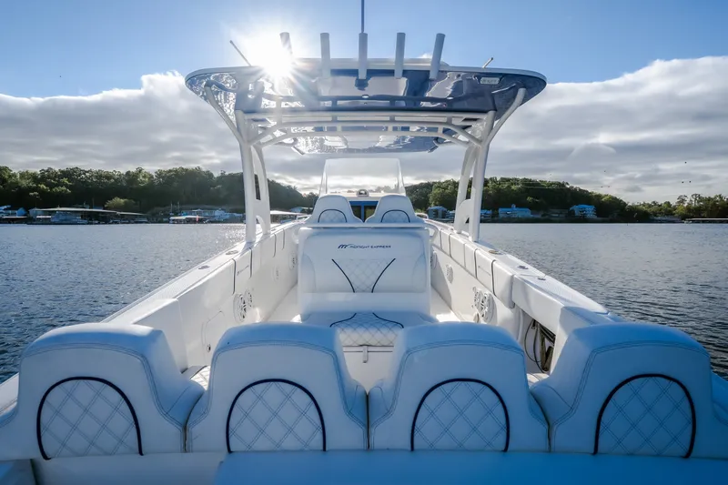 Slide: The Image of 2017 Midnight Express 39S Cuddy boat on serene water with sunlit sky. - 13