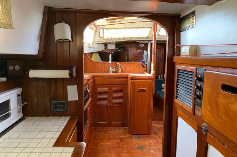 Slide: The Image of Interior of a 1981 Hardin 45 sailboat, featuring a wooden galley and cozy living space. - 16