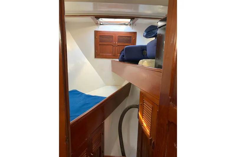 Slide: The Image of Cozy cabin interior of 1981 Hardin 45 sailboat with wooden finishes and blue bedding. - 21