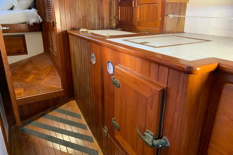 Slide: The Image of Wooden interior of a 1981 Hardin 45 yacht, featuring cabinets and a cozy cabin space. - 32