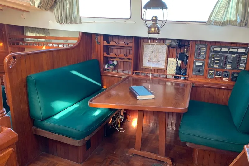 Slide: The Image of Interior of 1981 Hardin 45 sailboat with wooden dining area and green seating. - 38