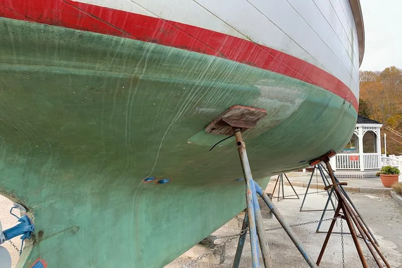 Slide: The Image of 1981 Hardin 45 sailboat hull on stands, green and red paint, outdoor setting. - 47