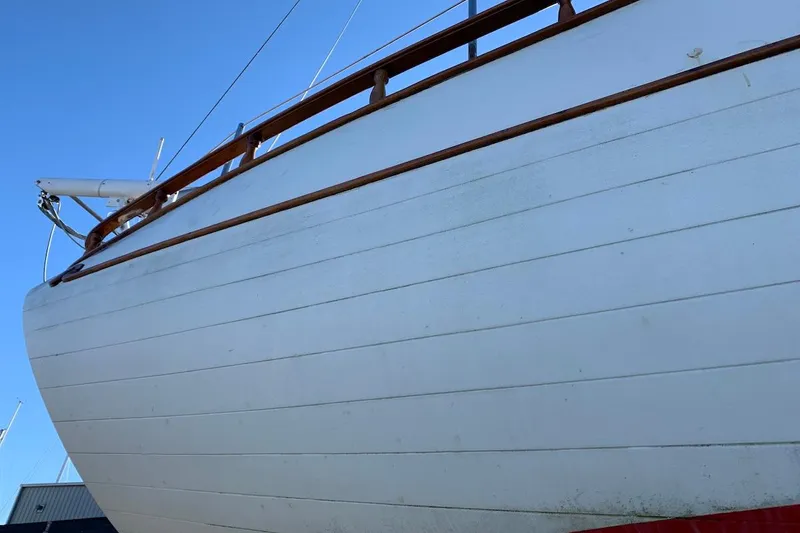 Slide: The Image of 1981 Hardin 45 sailboat hull with wooden trim against clear blue sky. - 51