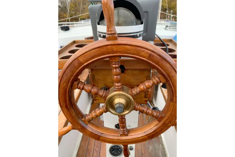Slide: The Image of Wooden steering wheel of a 1981 Hardin 45 sailboat, showcasing classic nautical design. - 55