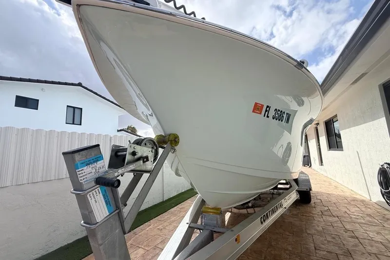 Slide: The Image of 2024 Sea Pro 222 Center Console boat on trailer, parked in driveway. - 2