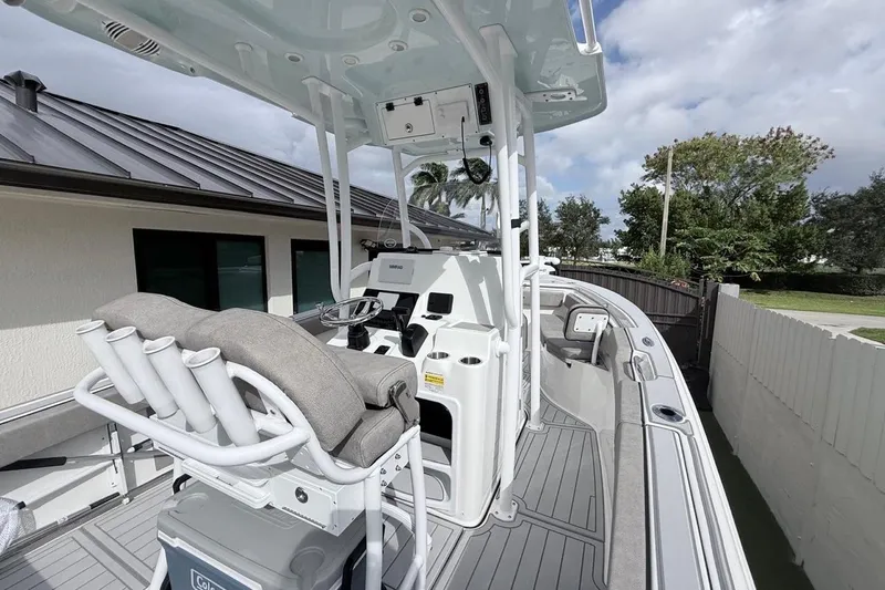 Slide: The Image of 2024 Sea Pro 222 Center Console boat with modern helm and seating, docked outdoors. - 22