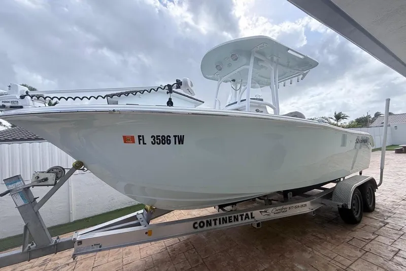 Slide: The Image of 2024 Sea Pro 222 Center Console boat on trailer, parked outdoors under cloudy sky. - 3
