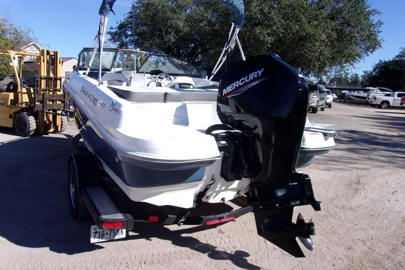 Slide: The Image of 2021 Tahoe 550 TF boat with Mercury engine on trailer in outdoor setting. - 4