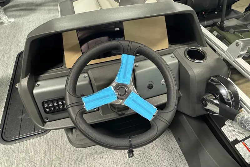 Slide: The Image of Steering console of 2026 Sun Tracker SportFish 22 XP3 with modern controls and cup holder. - 16