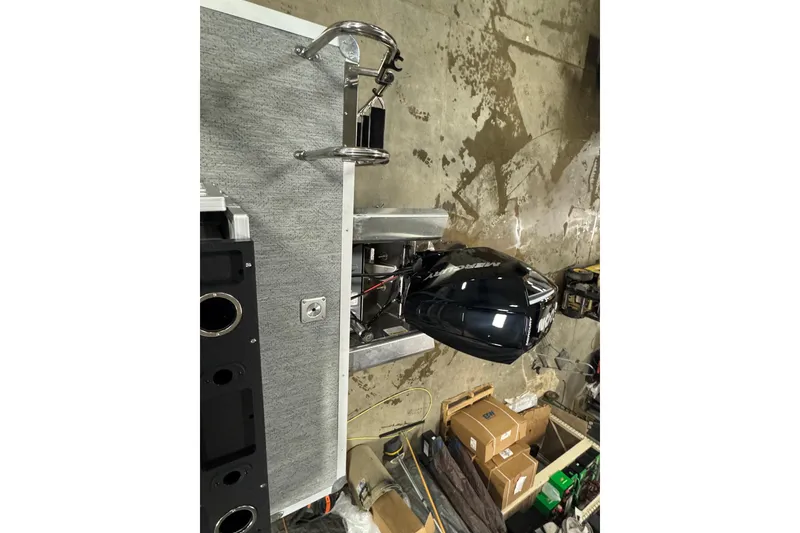 Slide: The Image of 2026 Sun Tracker SportFish 22 XP3 boat with Mercury outboard motor in a workshop. - 22