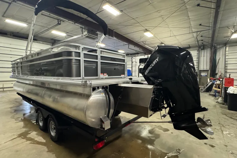 Slide: The Image of 2026 Sun Tracker SportFish 22 XP3 pontoon boat with Mercury outboard motor in a warehouse. - 4