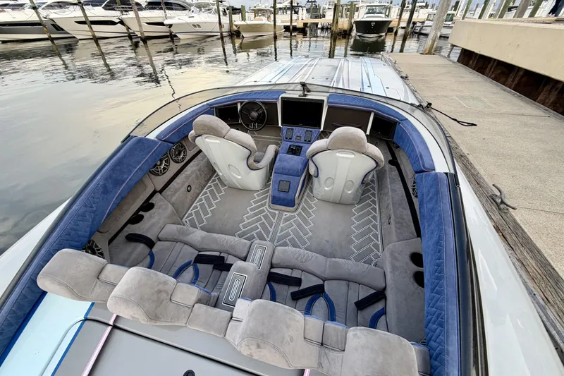 Slide: The Image of Luxurious 2024 Dug Wright 32 boat interior with plush seating and modern dashboard at a marina. - 14