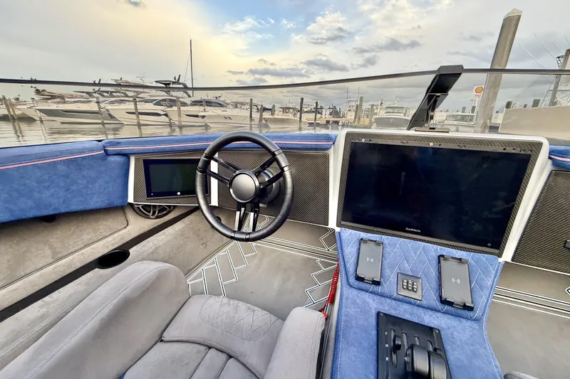Slide: The Image of 2024 Dug Wright 32 boat interior with modern dashboard and steering wheel at marina. - 17