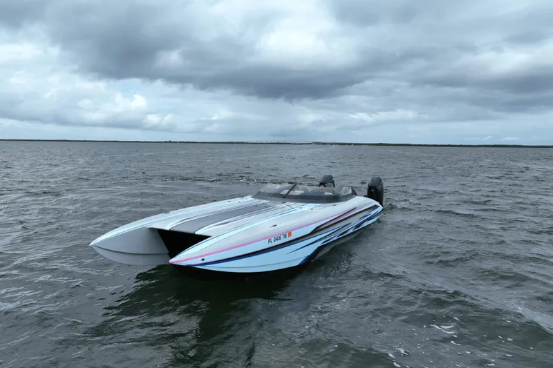 Slide: The Image of 2024 Dug Wright 32 speedboat on open water under cloudy skies. - 2