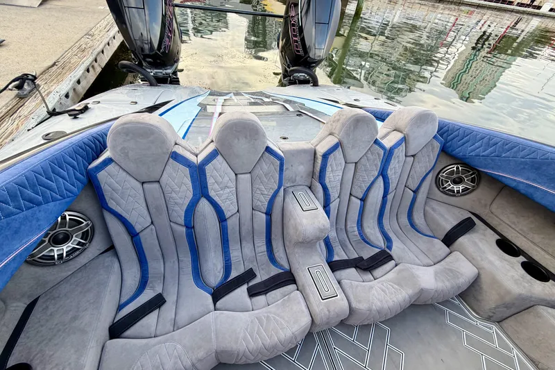 Slide: The Image of 2024 Dug Wright 32 boat interior with blue and gray seating, docked by the water. - 24