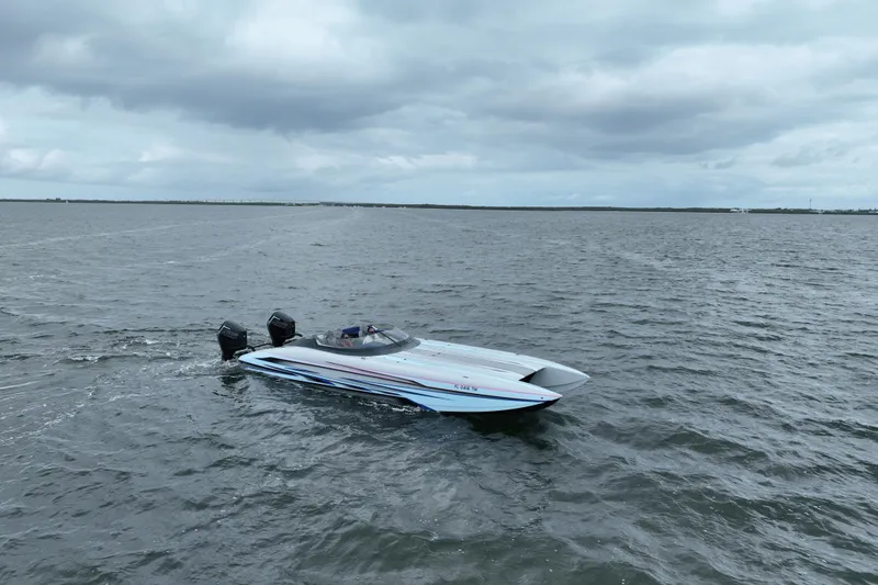 Slide: The Image of 2024 Dug Wright 32 speedboat cruising on open water under cloudy skies. - 4