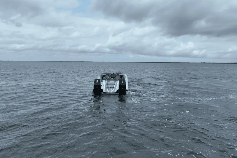 Slide: The Image of 2024 Dug Wright 32 boat cruising on open water under cloudy skies. - 7