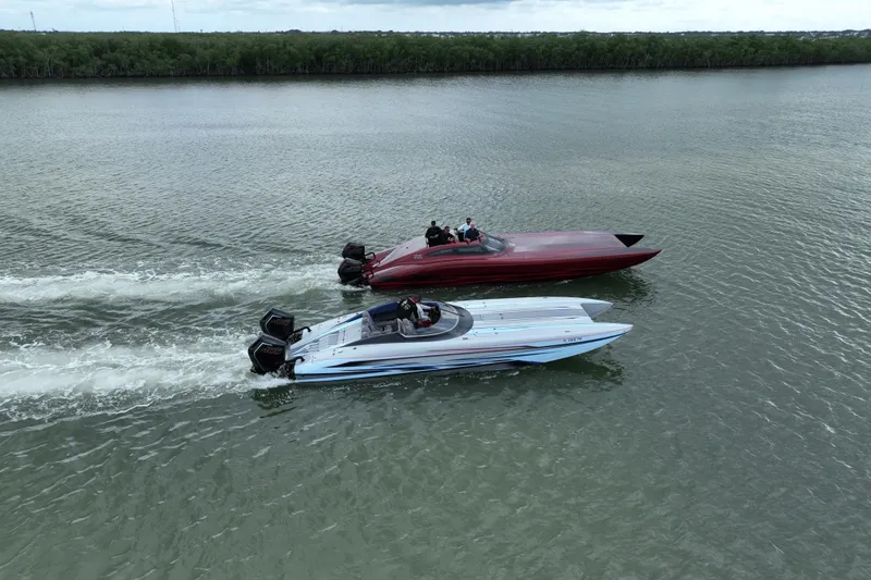 Slide: The Image of Two high-performance Dug Wright 32 boats racing on a calm waterway, 2024 model. - 9