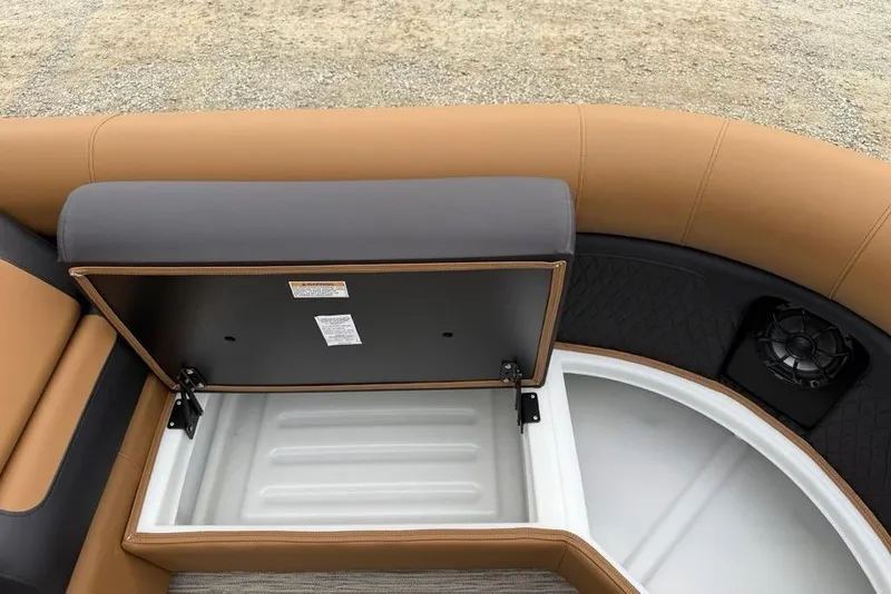 Slide: The Image of 2026 Premier 230 Sunsation RS CL boat seat storage compartment, open with tan and gray upholstery. - 10