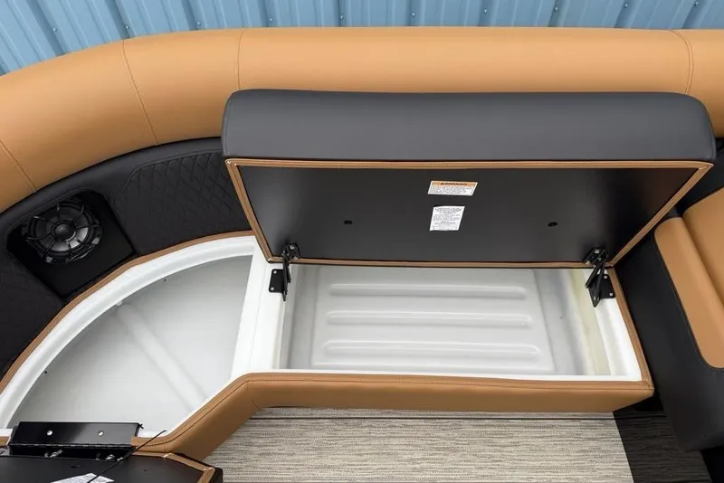Slide: The Image of 2026 Premier 230 Sunsation RS CL boat seat storage compartment, open with visible speaker. - 11