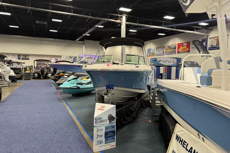 Slide: The Image of Manufacturer Provided Image: 2025 Robalo R207 Dual Console boat, rear view with outboard motor, sleek design. - 16