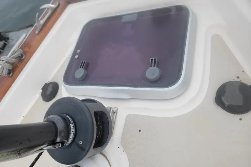 Slide: The Image of Deck detail of a 2008 Island Packet 370 sailboat, featuring a hatch and winch. - 19