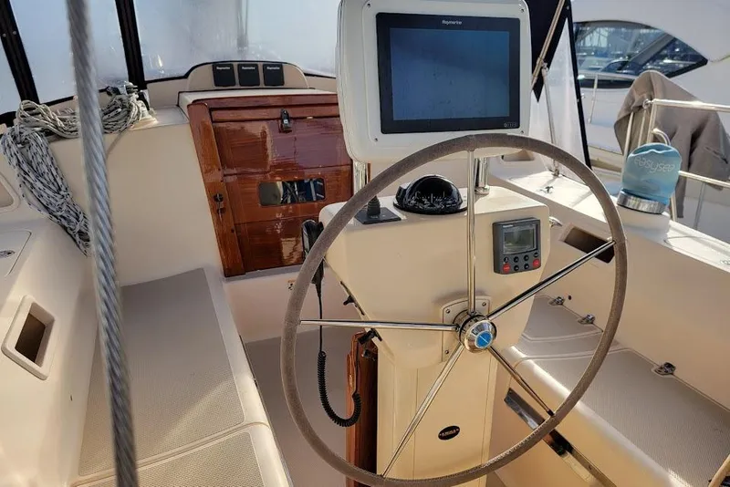 Slide: The Image of 2008 Island Packet 370 sailboat cockpit with steering wheel and navigation equipment. - 30