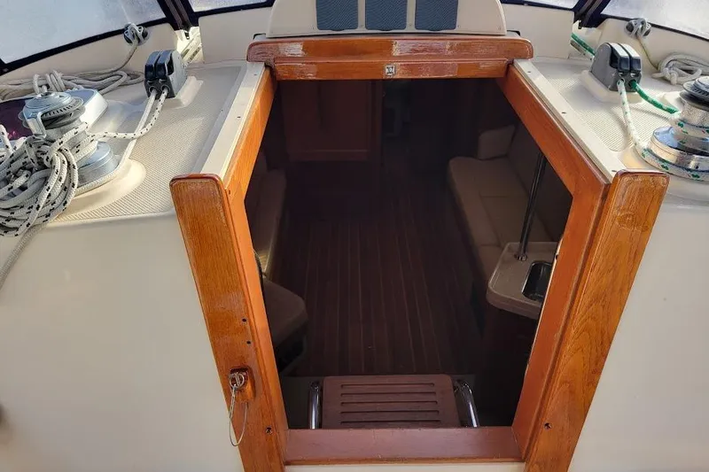 Slide: The Image of Interior view of 2008 Island Packet 370 sailboat, featuring wooden trim and seating area. - 34